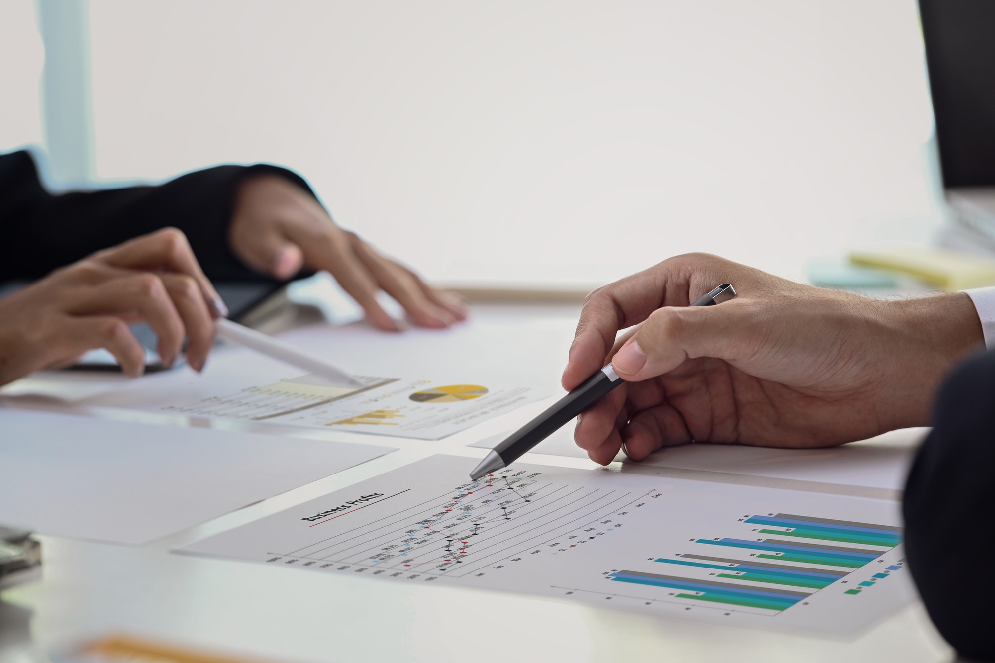 Close up view group of financial advisor analyzing graph together at office desk.